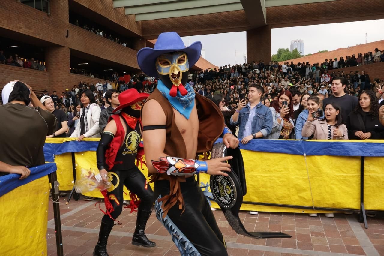 Luchador con sombrero y cinturón de campeonato entre el público